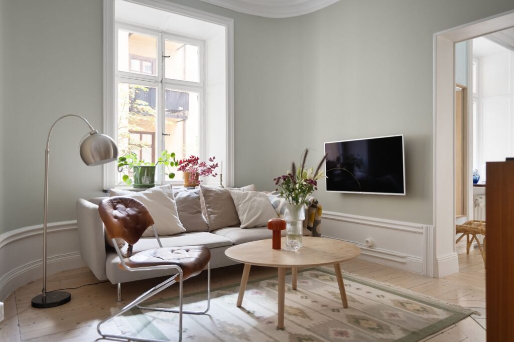 Lys skandinavisk stue med sofa, bord og boligindretning